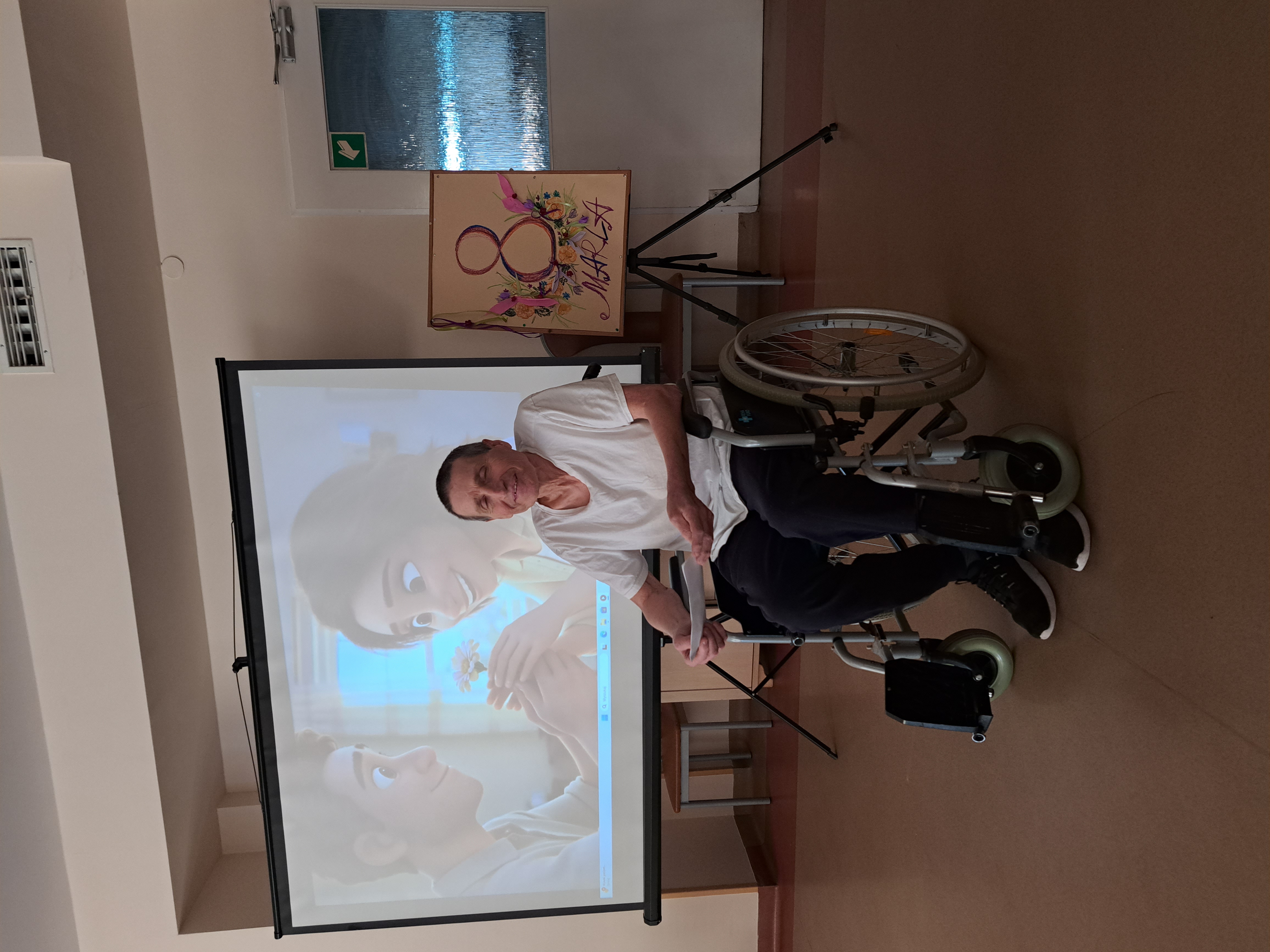 Senior siedzący na wózku inwalidzkim składa życzenia z okazji Dnia Kobiet